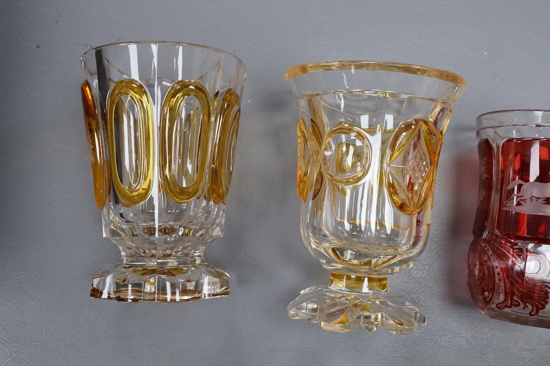 Four Bohemian engraved amber or ruby flashed ‘hunting’ goblets or beakers, late 19th century, tallest 15cm high